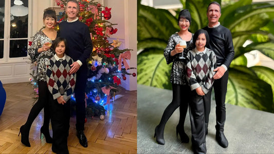 Couple in holiday sweaters beside their custom 3D figurine by a Christmas tree