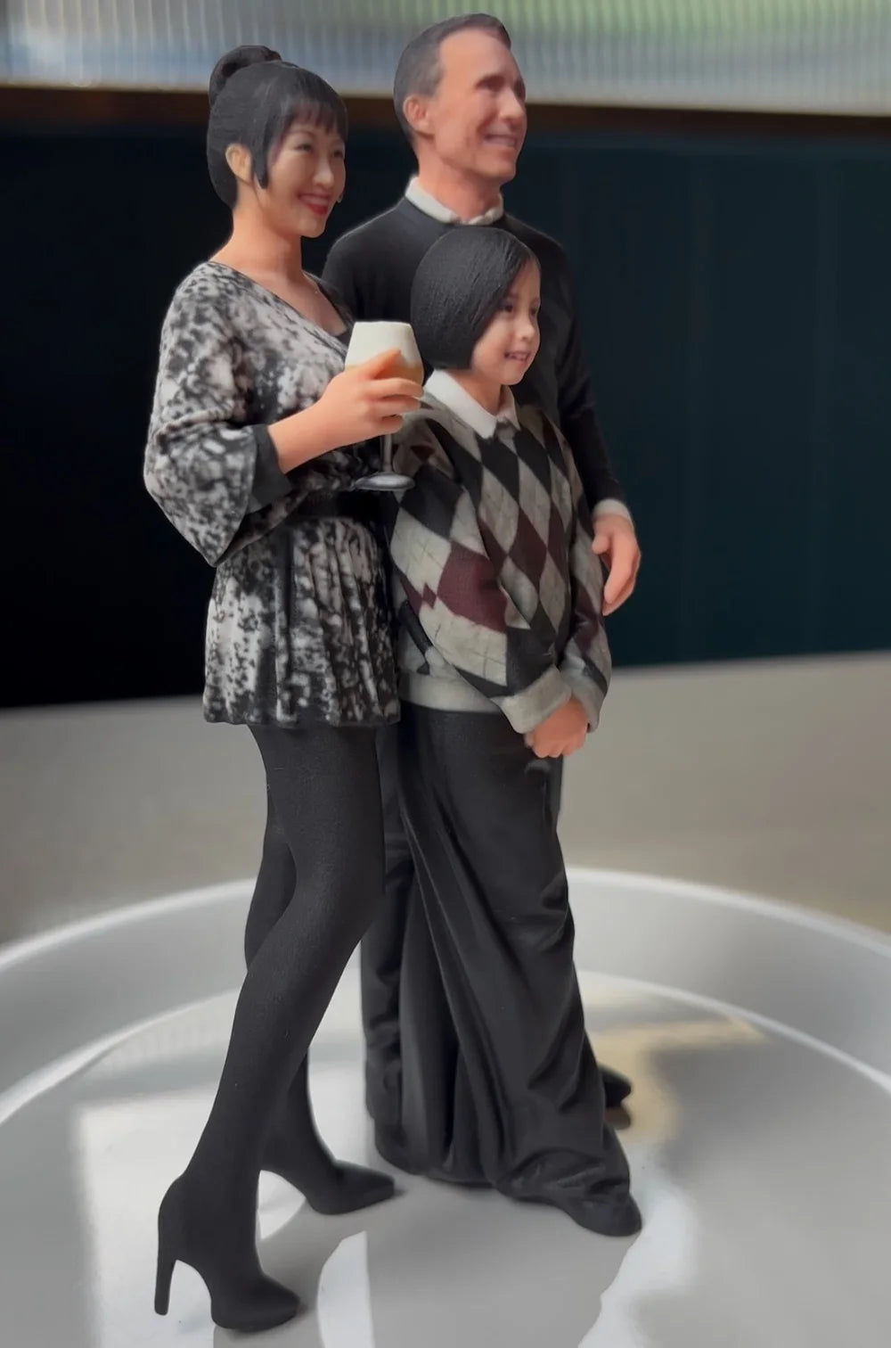 Three-quarter view of a personalized resin family figurine of a mother, father and daughter
