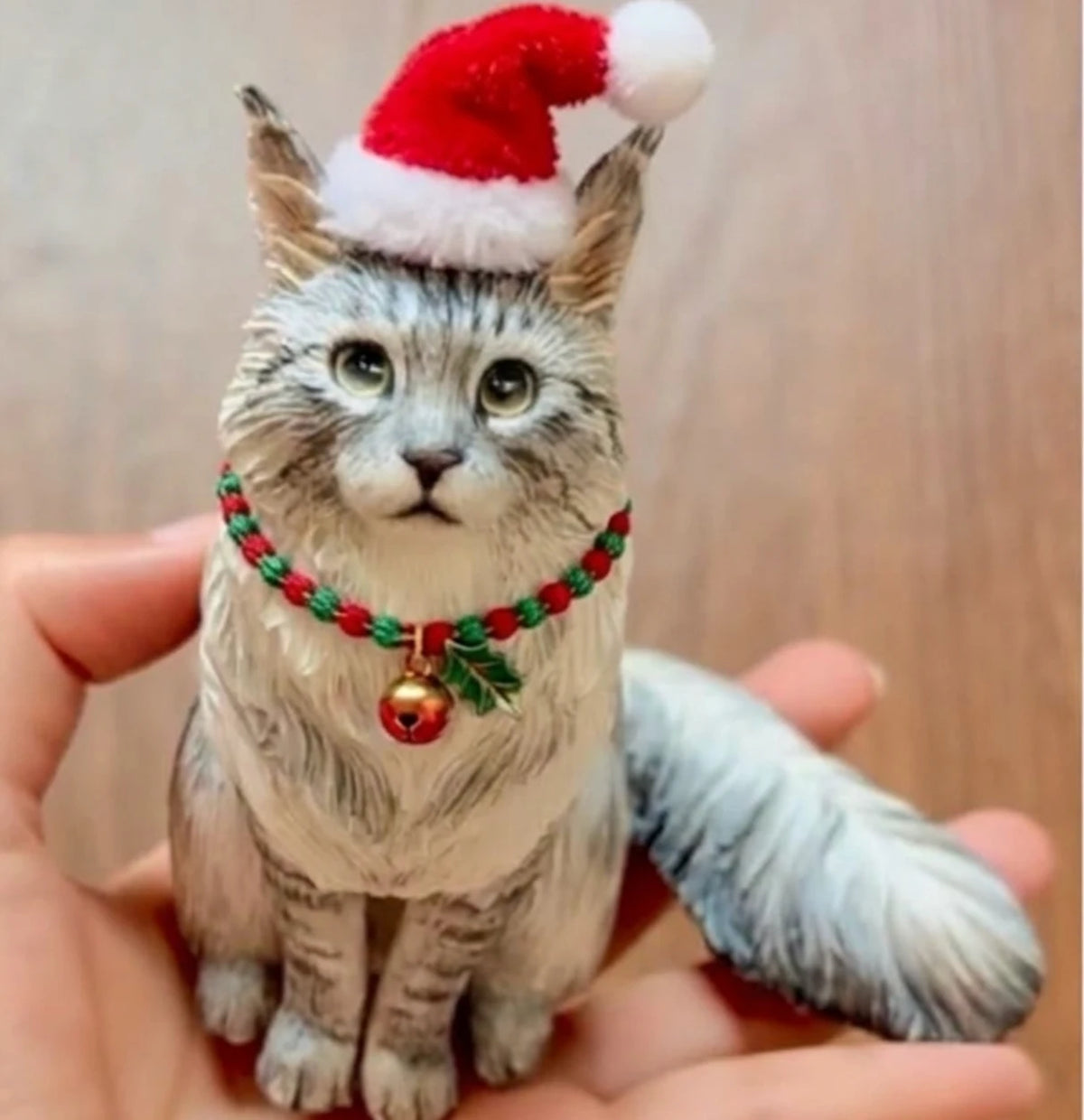 Custom 3D printed cat figurine in a Santa hat and jingle-bell collar, held in a hand to show its size